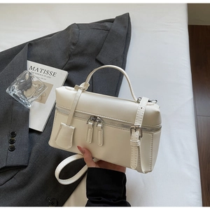 Sac bandoulière blanc carré avec fermeture éclair en métal et bandoulière sur fond studio