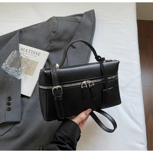Détail du sac carré noir texturé avec fermetures éclair et bandoulière amovible