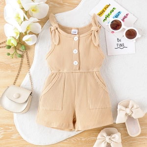 Dettaglio pagliaccetto neonato beige in maglia a coste con fiocchi e bottoni