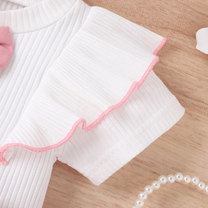 Detailaufnahme von weißem Rippstrick mit rosa Schleife und Rüschenärmeln für Mädchen