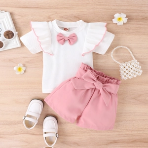 Detailansicht Mädchen Sommer-Outfit mit weißem Oberteil und rosa Schleifen-Shorts