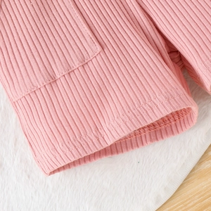 Dettaglio ravvicinato della trama in maglia a coste rosa e finitura con doppia cucitura