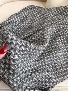 Vue détaillée du tissu en tweed noir et blanc de haute qualité avec un motif tissé texturé