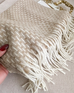 Gros plan sur l'écharpe à carreaux beige épais avec des franges douces et maille texturée