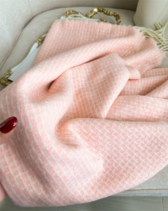Détail de l'écharpe en tweed rose et blanc montrant les franges et la texture du tissu épais