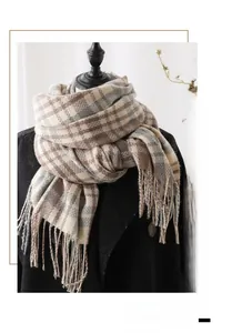 Detail of a plaid cashmere-feel scarf with fringes on a model for a warm look