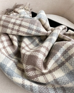 Close-up of thick plaid cashmere scarf with soft textures and fringe details