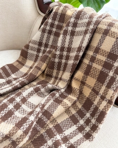 Detailed view of soft brown and beige plaid cashmere-like scarf texture and knit weave