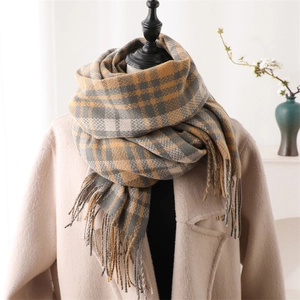 Women's plaid cashmere scarf in yellow and grey with tassels on a mannequin