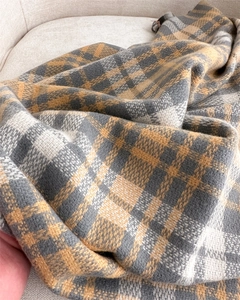 Detailed texture of thick plaid scarf in yellow and grey with warm cashmere feel