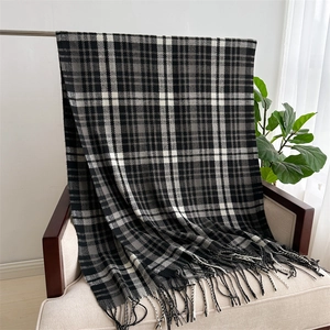 Detail of classic black white and grey plaid scarf with long decorative tassels