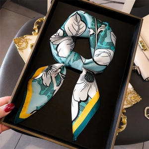 Close-up of silk scarf with floral print and yellow edges tied in an elegant bow