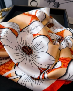 Detailed view of floral print silk scarf with camellia pattern and soft satin texture