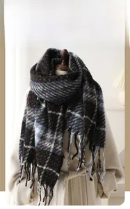 Close-up of winter knit plaid scarf with multi-color grid pattern and long fringe detail
