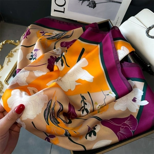 Texture détaillée d'un foulard en soie avec imprimé de lys et bordure contrastée