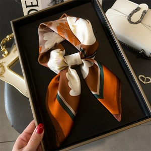 Carré de soie style français avec imprimé floral orange et marron sur un plateau