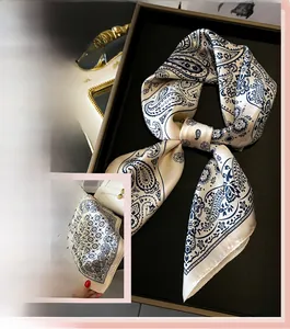 Detail eines seidigen Satintuchs mit klassischem dunkelblauem Paisley-Print auf Beige