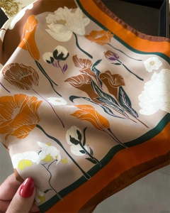 Vue détaillée d'un carré de soie rétro à fleurs avec texture satinée et bordure colorée