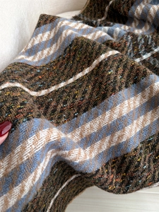 Detailed macro view of heavy zigzag weave scarf with mixed brown and blue yarn textures