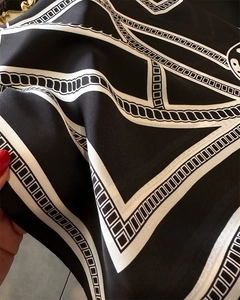 Detailed view of luxury silk-like scarf featuring classic chain prints and satin texture