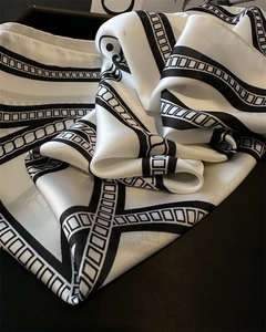 Close-up of black and white geometric chain print silk scarf with satin luster detail