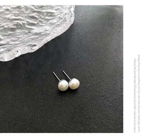 Vista macro de pendientes de perlas naturales blancas con tuercas de plata s925 pura