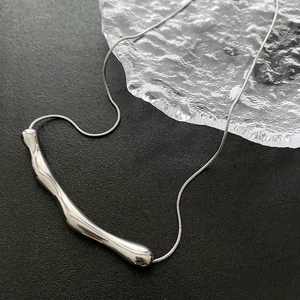 Collana in argento con ciondolo irregolare effetto lava e catena a serpente su sfondo nero