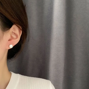 Pendientes de perlas naturales minimalistas en plata S925 usados por una modelo