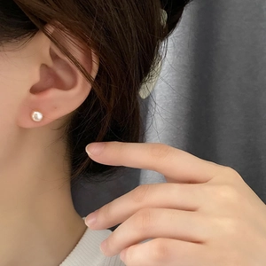 Pendientes de plata s925 con perlas blancas naturales mostrados en una modelo