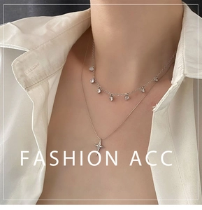 Gros plan d'un collier double épaisseur en argent avec pendentif étoile et zircons sur modèle