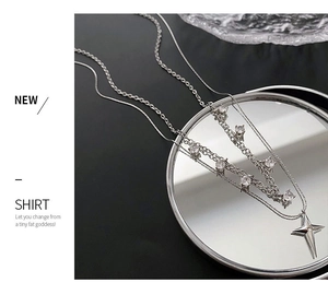 Vue détaillée d'un collier argenté multicouche avec pendentif étoile et zircons