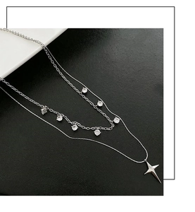 Détail d'un collier double épaisseur en argent avec pendentif étoile et zircons brillants