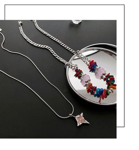Close-up of double-layered beaded necklace with pink star pendant on a black surface