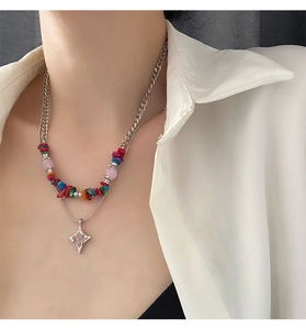 Close-up of double-layered necklace with colorful beads and a star pendant on a model
