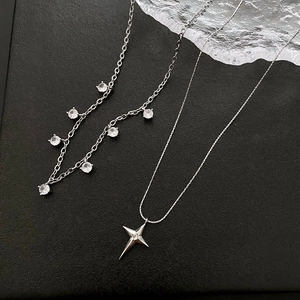 Élégant collier double épaisseur en argent avec pendentifs étoiles en zircon sur fond noir
