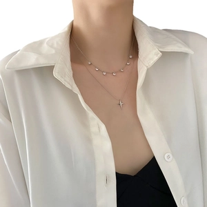 Collier double rang argenté avec pendentif étoile et zircons porté sur fond blanc