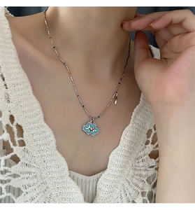 Detail of beaded necklace featuring a crystal cloud pendant with smiley face and stars