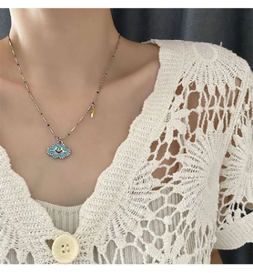 Detail of blue cloud pendant with colorful smile and beads on silver chain