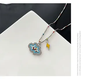Macro detail of enamel cloud and lightning charms with colorful beads on a silver chain