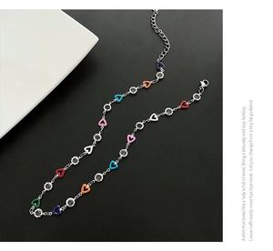 Macro shot of silver chain necklace with multi-colored enamel hearts and clear zircons