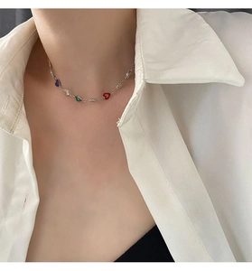 Detail of colorful heart pendants on silver chain necklace worn by a model