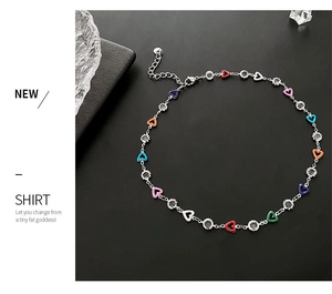 Detail of silver chain necklace featuring multi-colored hearts and round crystal accents