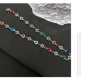 Detailed view of silver necklace with colorful enamel hearts and cubic zirconia charms