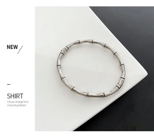 Détail du bracelet rigide argenté style bambou avec une finition métallique polie