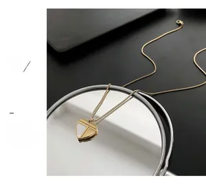 Détail d'un collier cœur doré avec incrustation de nacre reflété dans un miroir rond