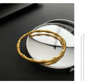 Gros plan détaillé d'un bracelet jonc doré style bambou avec finition métal poli