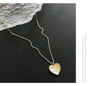 Détail macro du collier coeur en or 18 carats avec incrustation en nacre et chaîne fine