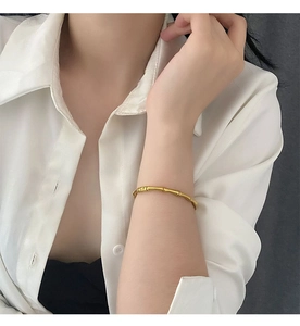 Gros plan détaillé d'un bracelet jonc doré style bambou au fini mat élégant