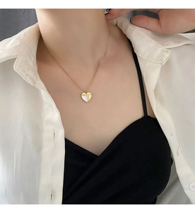 Détail du collier pendentif cœur avec incrustation de nacre et finition dorée polie