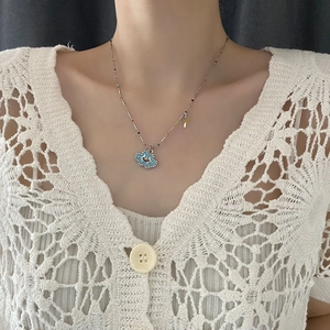 Chic silver necklace with blue cloud smiley face pendant and colorful beads on model